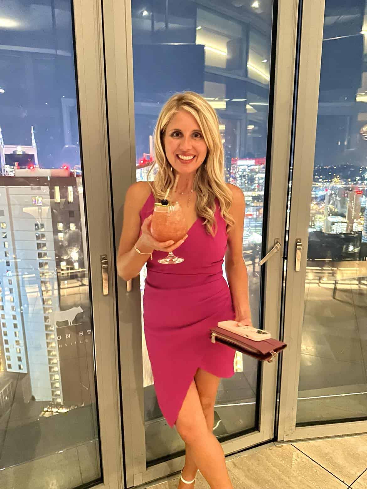 Non-alcoholic drink held by girl with the Nashville skyline behind her.