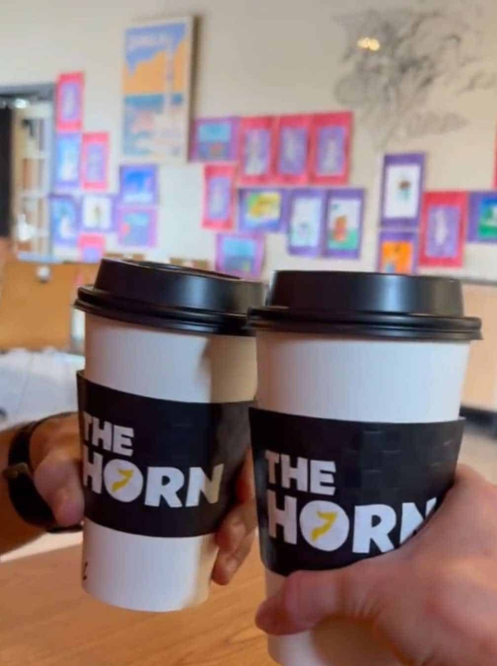 Two people tapping their non-alcoholic chai drinks.