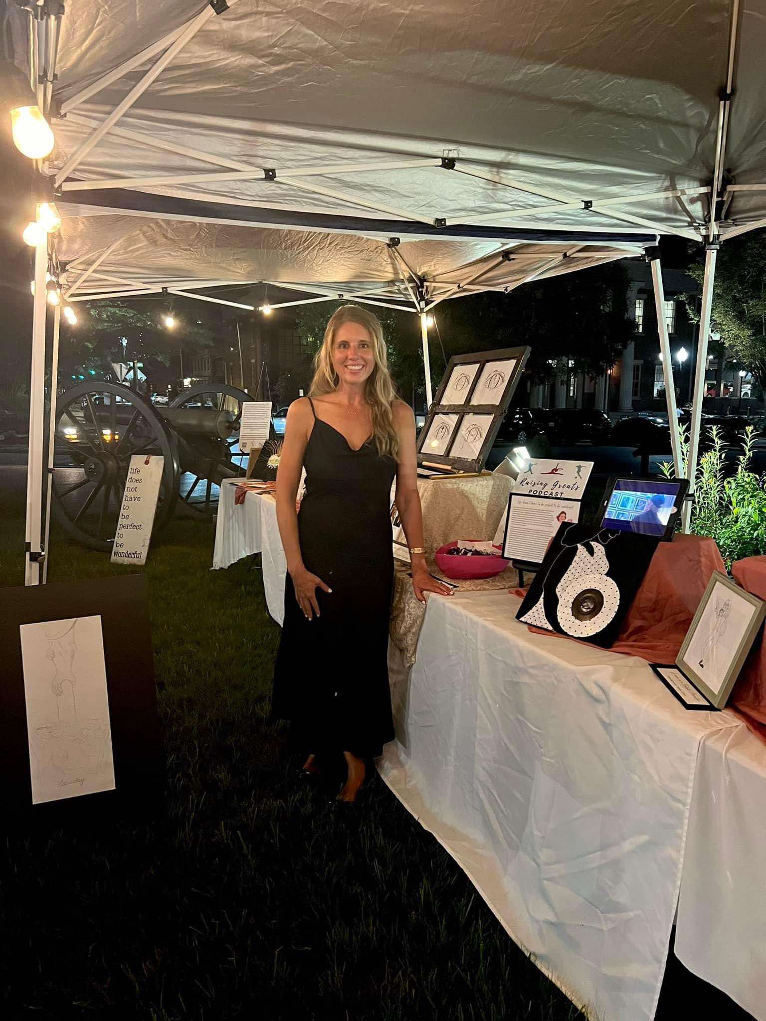 Franklin Art Crawl booth with woman standing in a black dress at her booth.