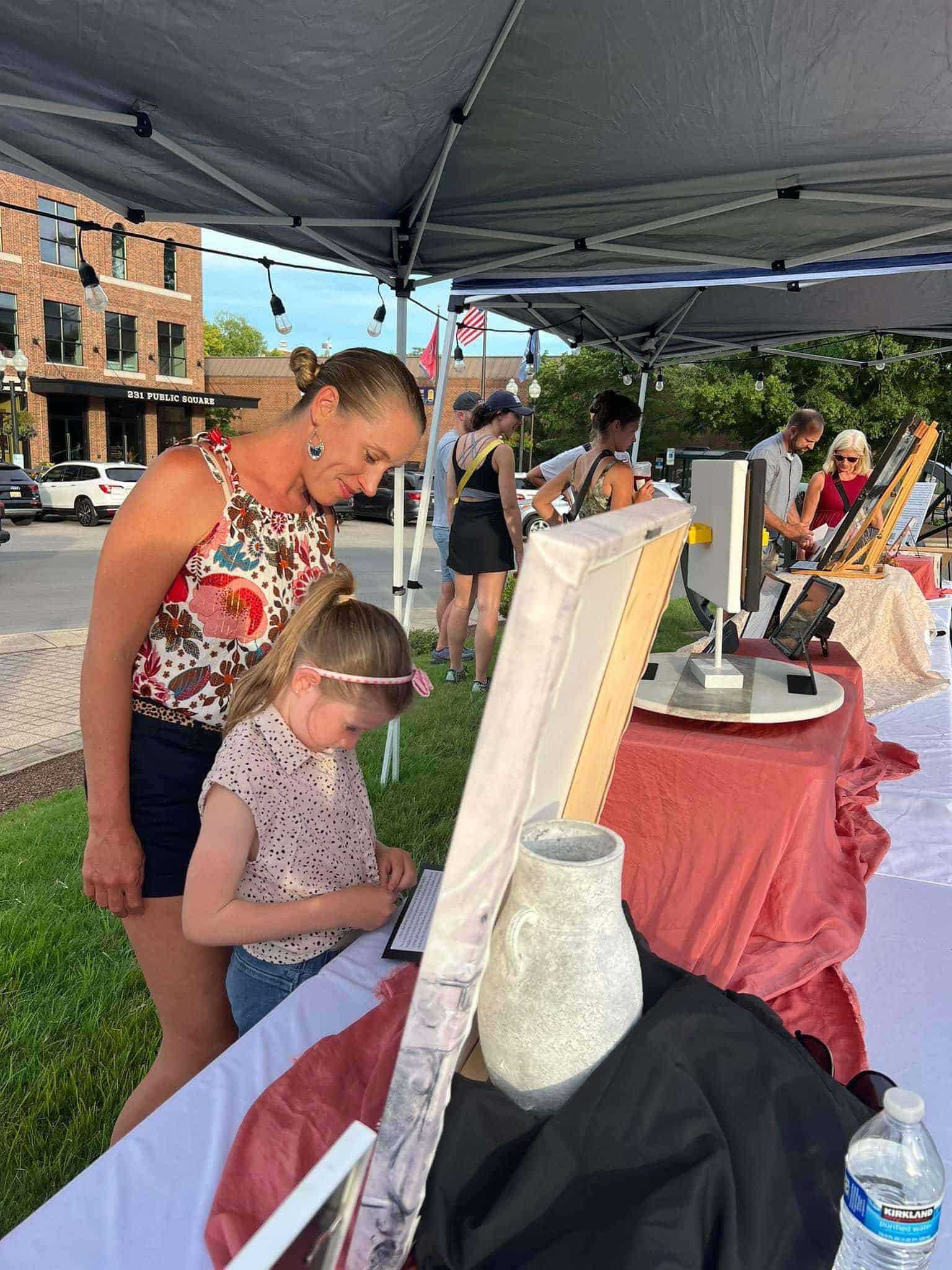 A mom and daughter look at art at the Franklin Art Crawl.