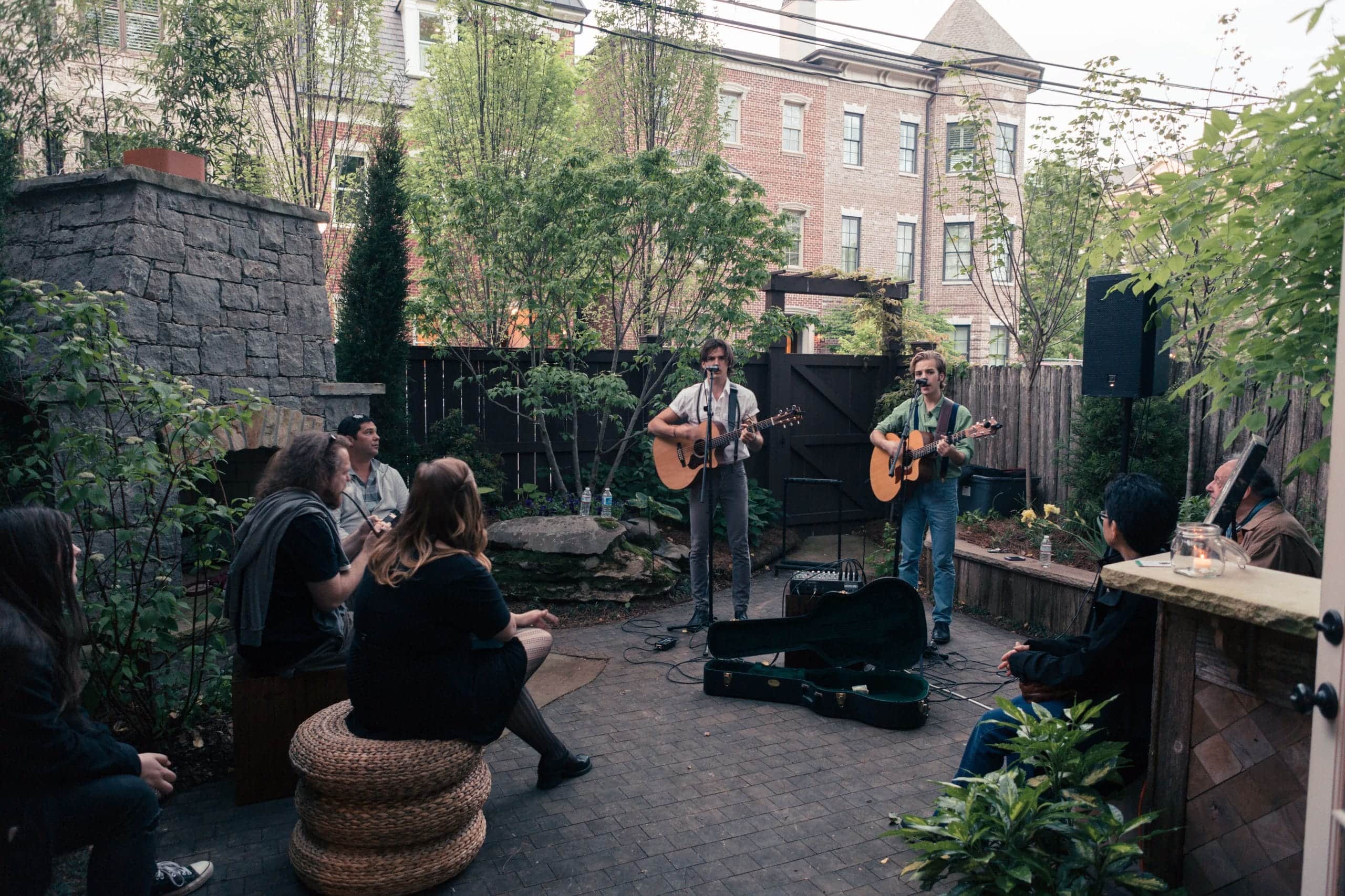 3 musicians play their guitars and sing in a pretty courtyard at the Franklin Art Craw.
