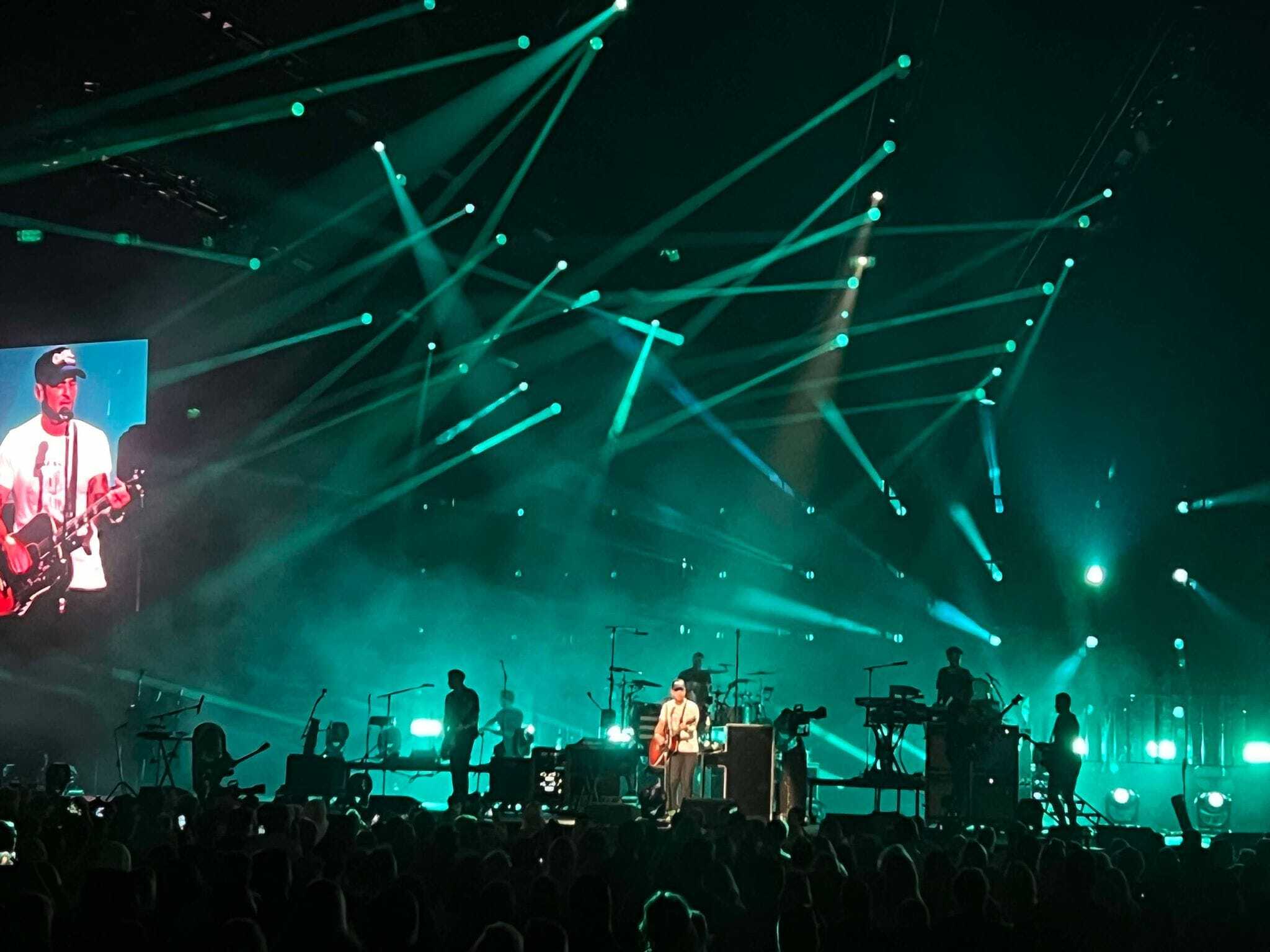 One Republic band on stage with green lights behind them.