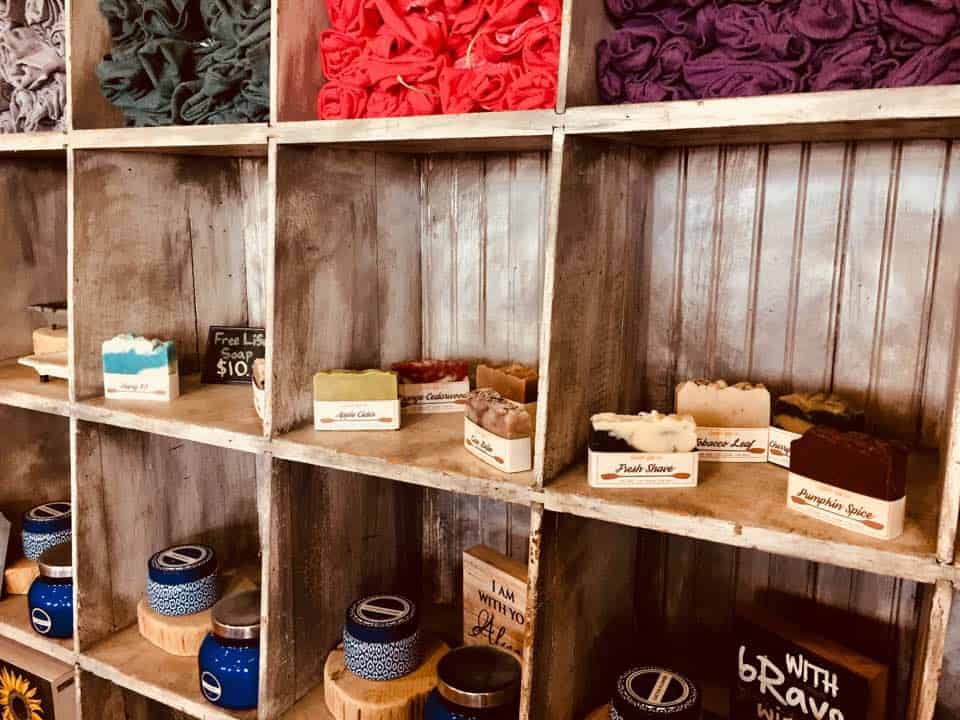 Inside a store with wood shelves and men's soap on the shelves.