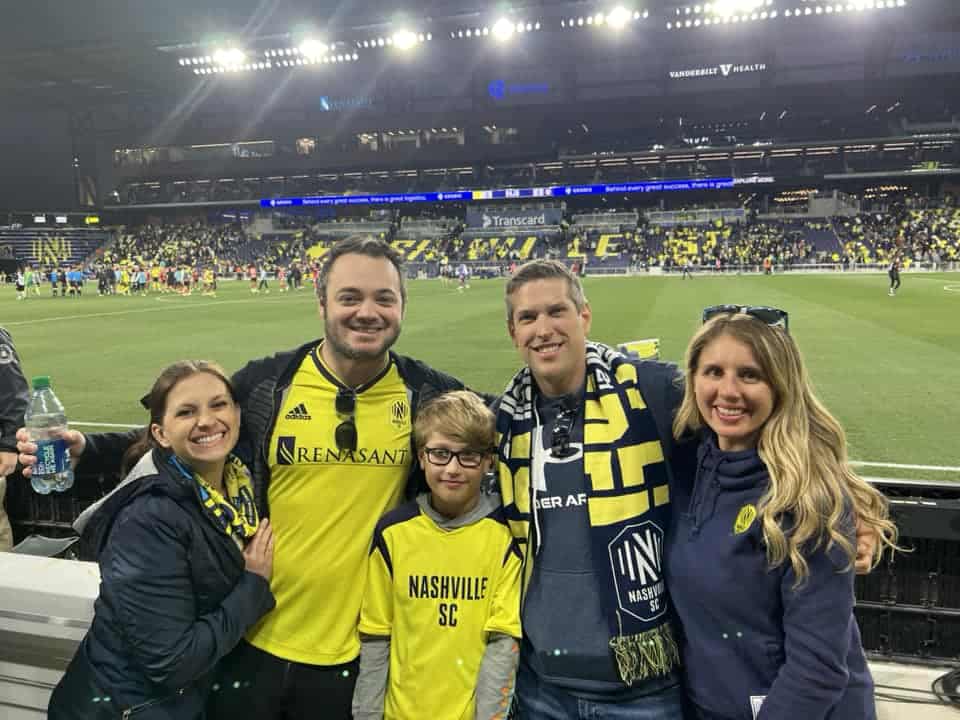 Friends at a Nashville Soccer Game in front of the soccer field.