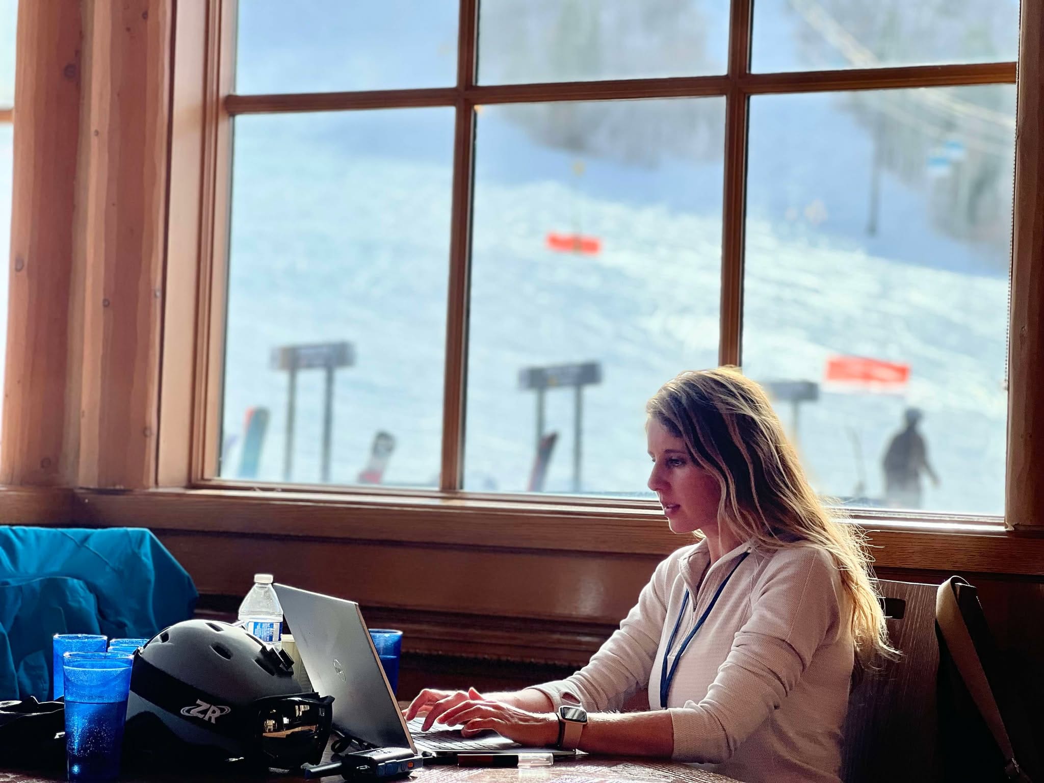 A mom working from her computer in Earl's Lodge at Snowbasin Ski Resort.