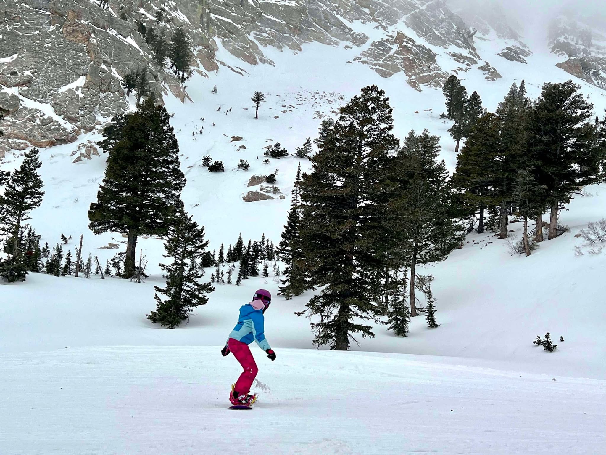A 9 year old girl snowboarding at Snowbasin Ski Resort while on a family snowboarding trip.