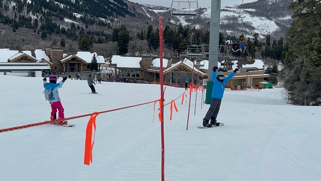A boy and girl celebrating with their arms up after the boy did a jump. 