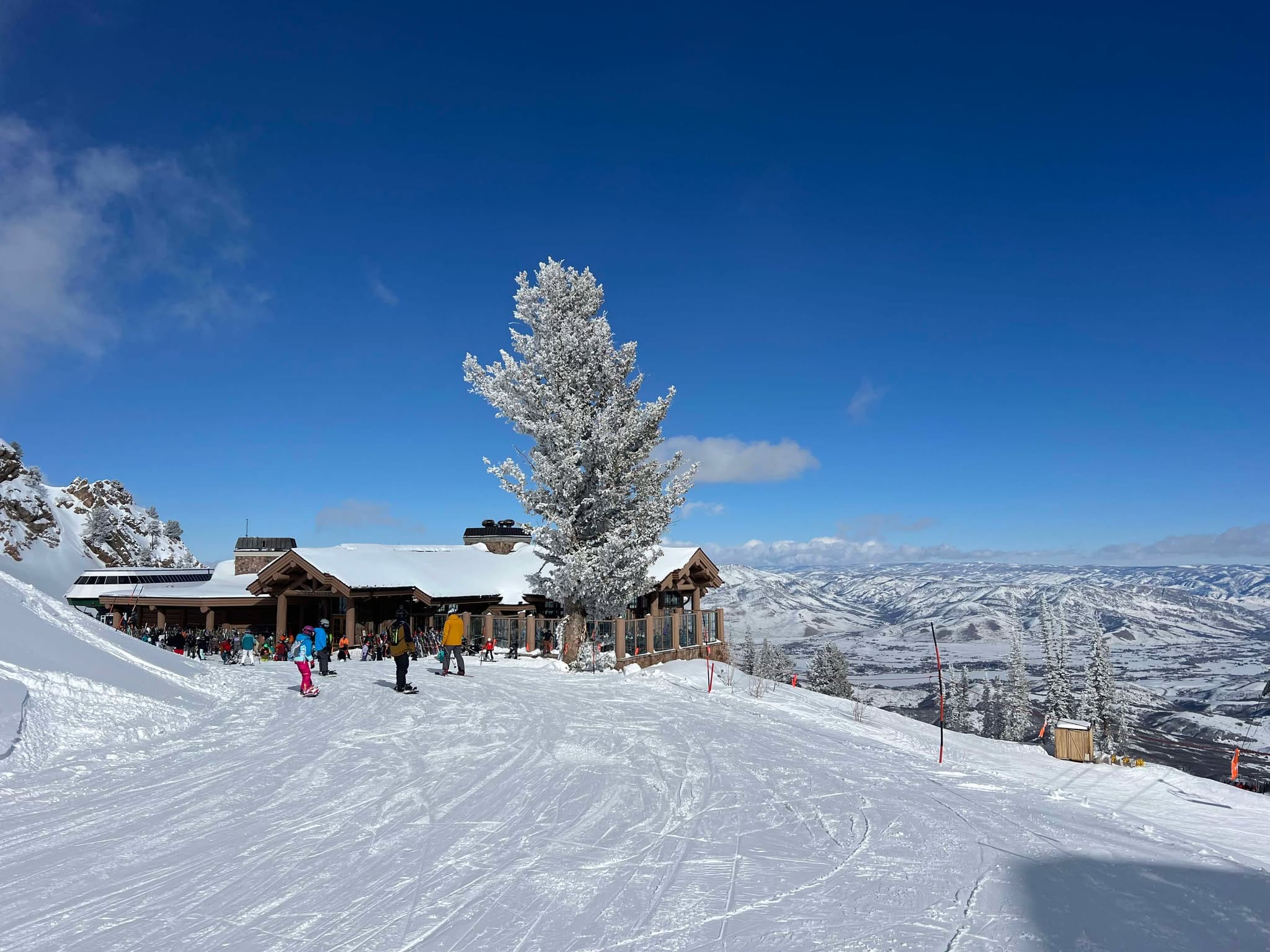 Snowbasin's Needles Lodge with skiers and snowboarders in front of it getting ready for their runs.
