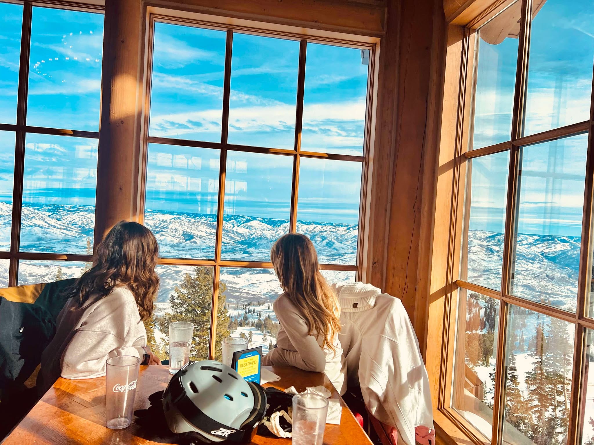 A mom and daughter look out the window of the mountain views at Snowbasin Ski Resort.