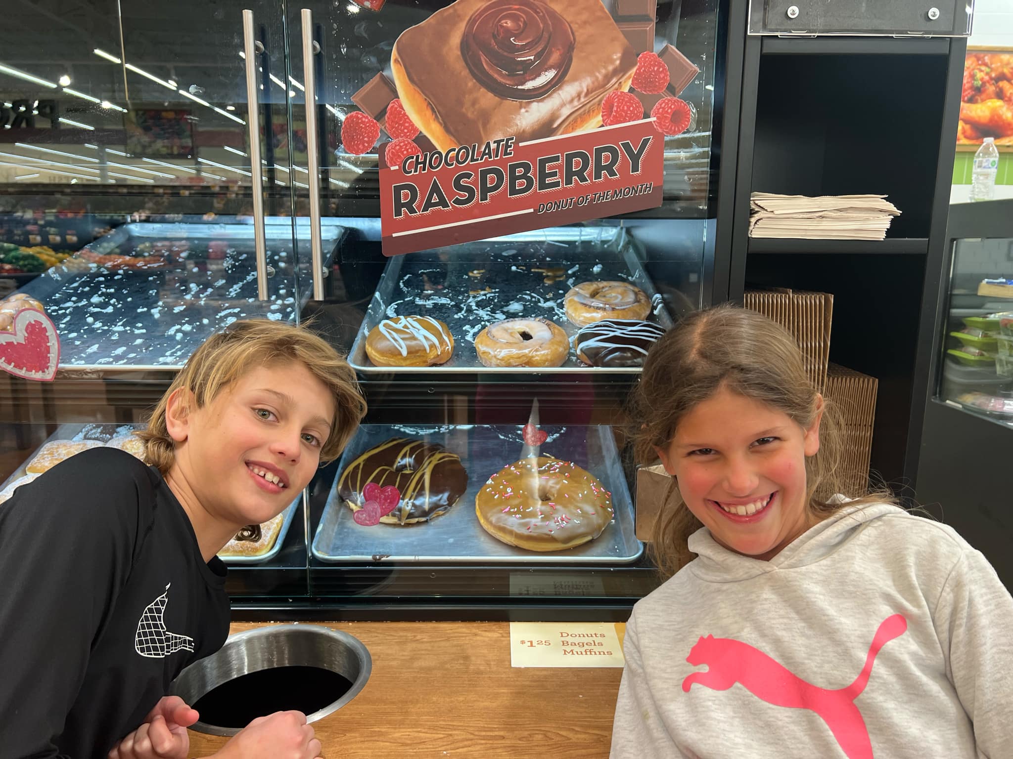 Two kids taking a picture with a "Texas sized donut".