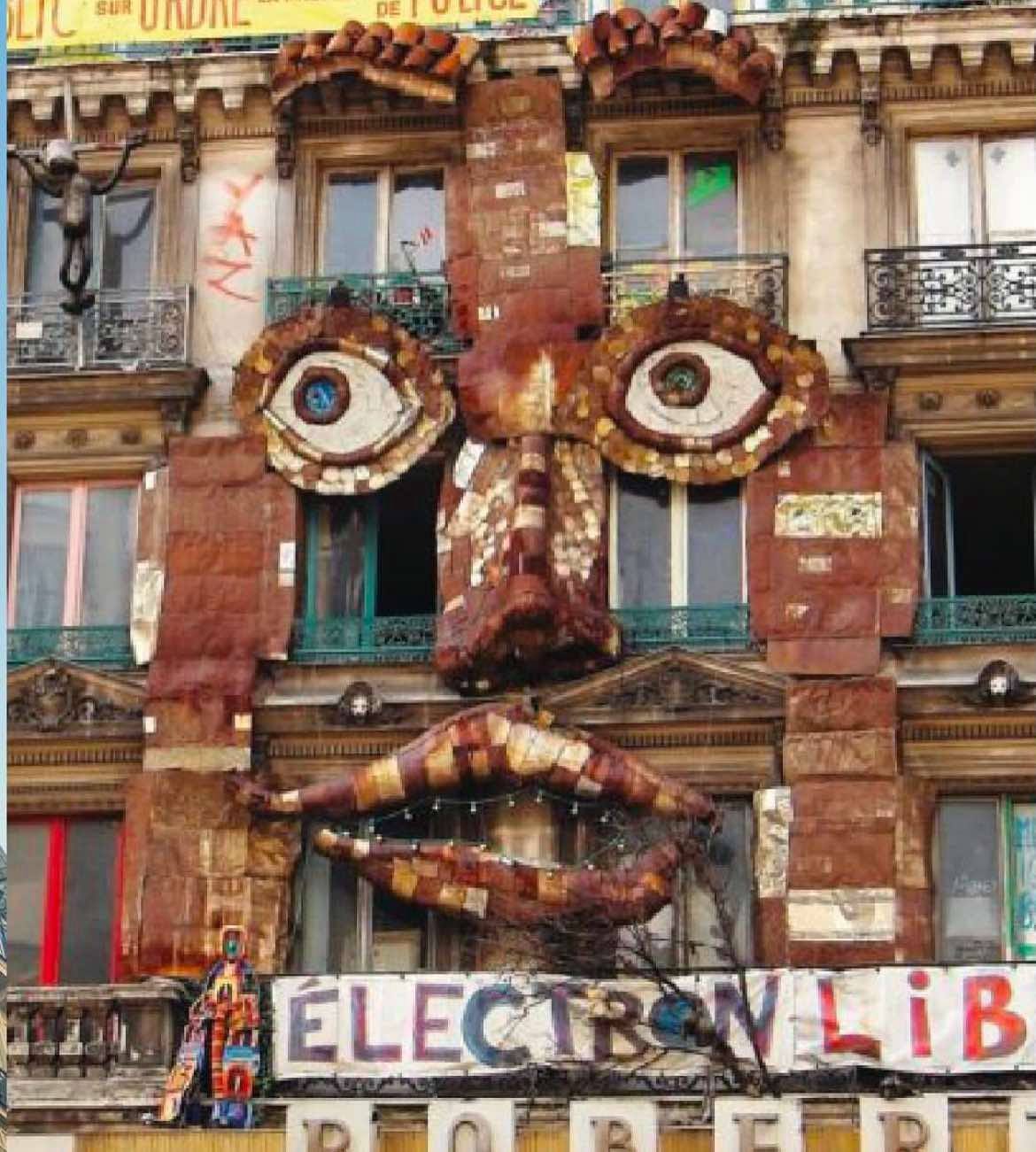 59 Rivoli's building with another massive structure attached to the building. This art piece is a face made out of brown, varied materials.
