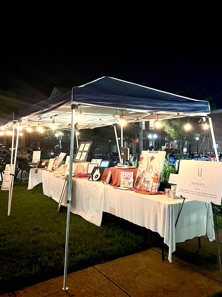 Picture of Natasha's art crawl booth at night. She was inspired by the Montmartre section of Paris, which is free to visit.