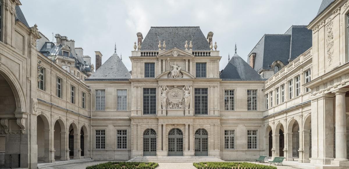 A photo of the Musee Carnavalet. It is a beautiful, white building with a gray roof.
