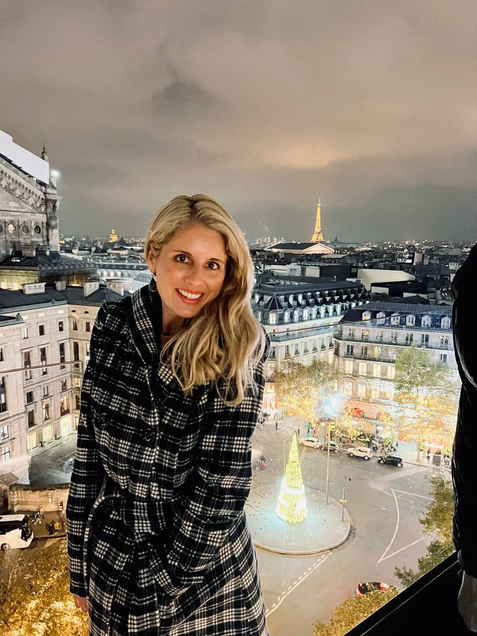 Girl standing on a free rooftop with Paris and the Eiffel Tower in the background.