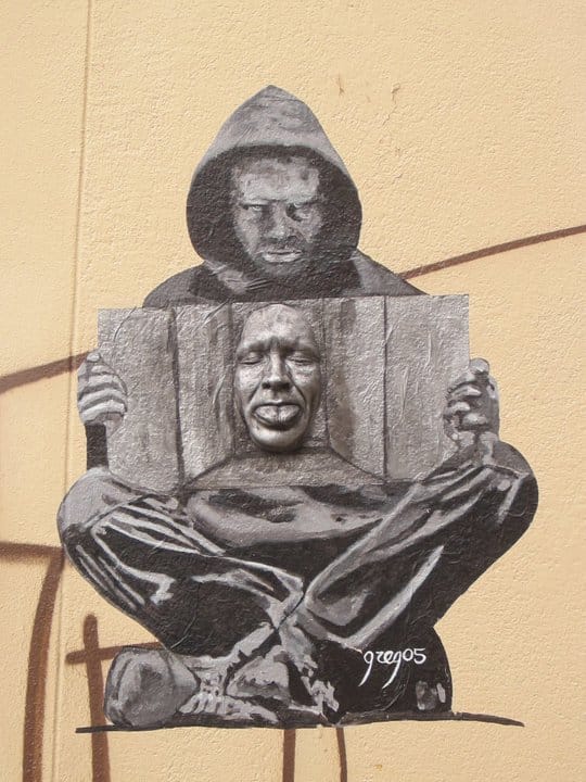 Artwork that is found in Montmartre area of a face coming out of the cement wall. There was a painting done around the face to look like a person (done in black and white) is holding the face.