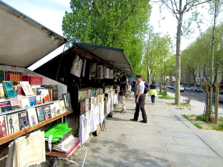 For this free things to do in Paris picture, there is a man standing at the Bounquinistes book stalls along the Seine River.