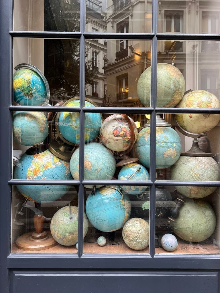 For this free things to do in Paris photo, there are a bunch of globes in a window front while I was window shopping.