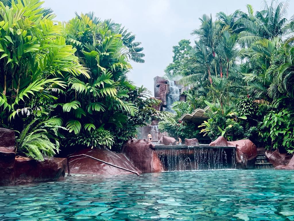 A turquoise hot spring with small waterfall at the Baldi Hot Springs Resort in Costa Rica.