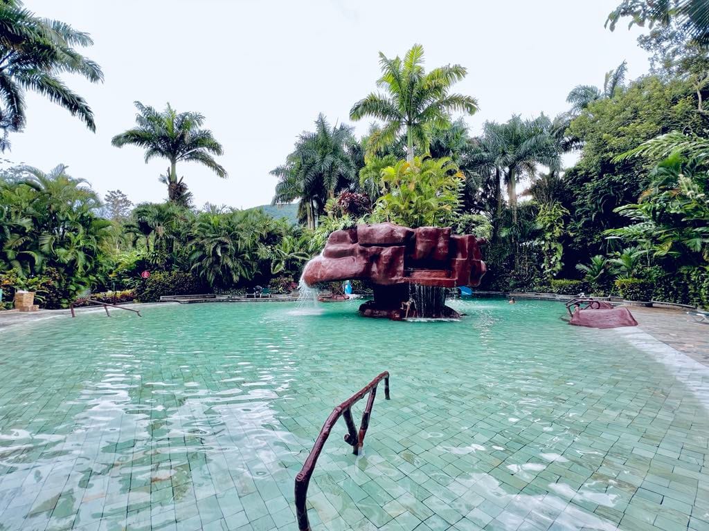 Another view of one of the hot springs at Baldi Resort in Costa Rica. This hot spring pool has a water feature that looks like a mushroom.
