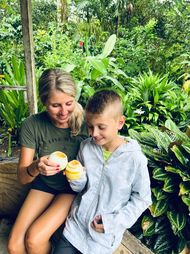 A mom and son sharing an orange drink at the chocolate farm while on their Costa Rica with Kids trip.