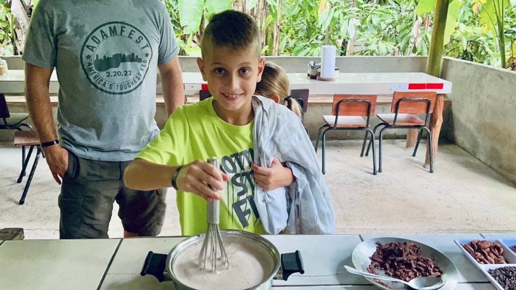 A little boy whisking chocolate milk at a chocolate farm on a Costa Rica with Kids trip.
