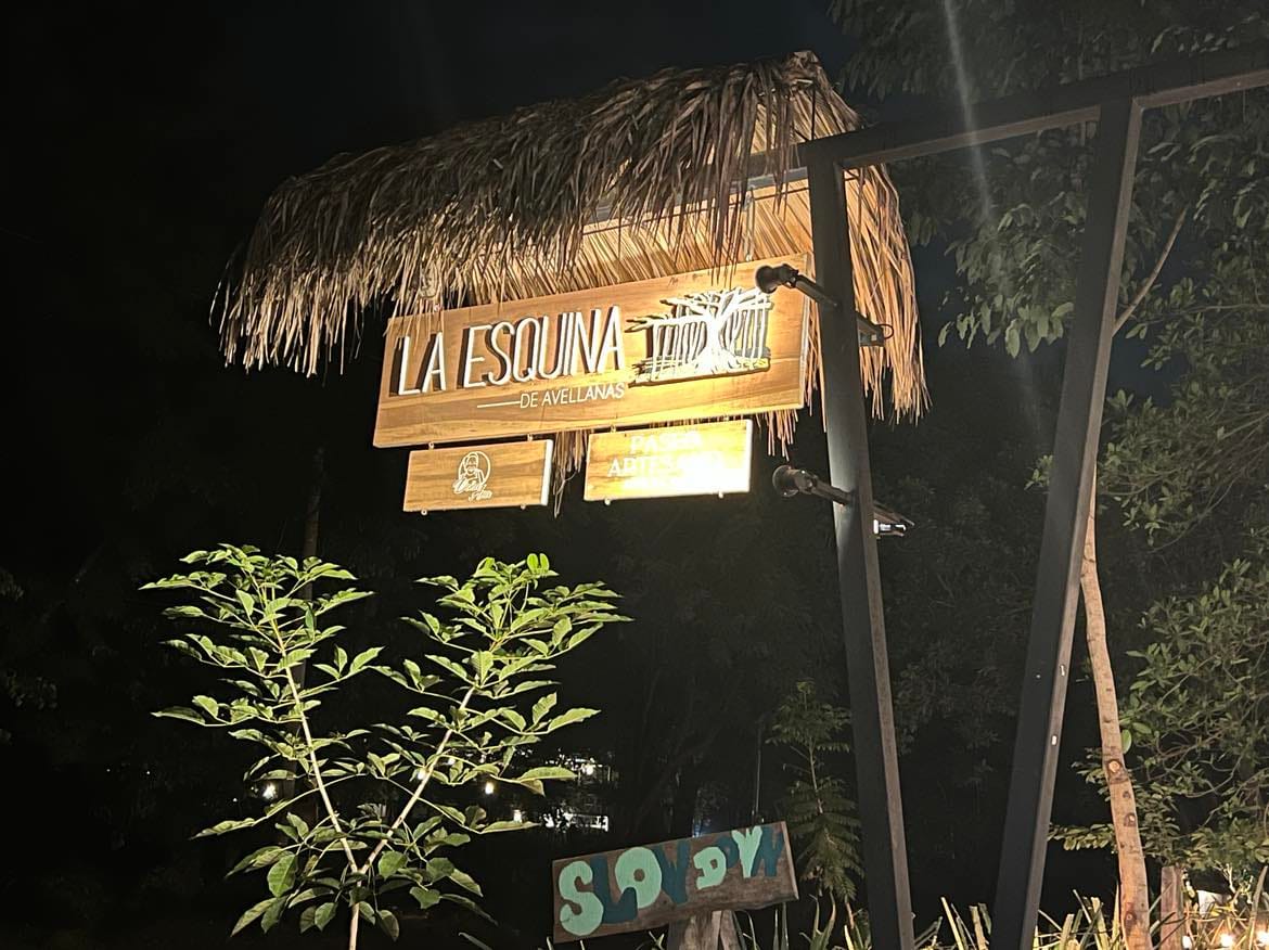 A picture of a sign with a grass top for the restaurant.