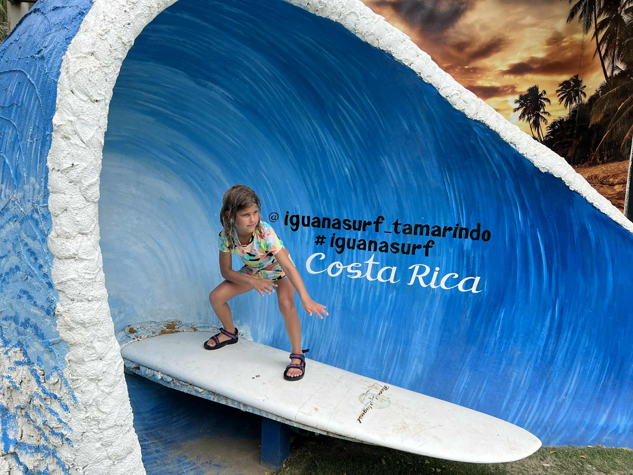 Little kid pretending to surf at a Costa Rica surf shop.