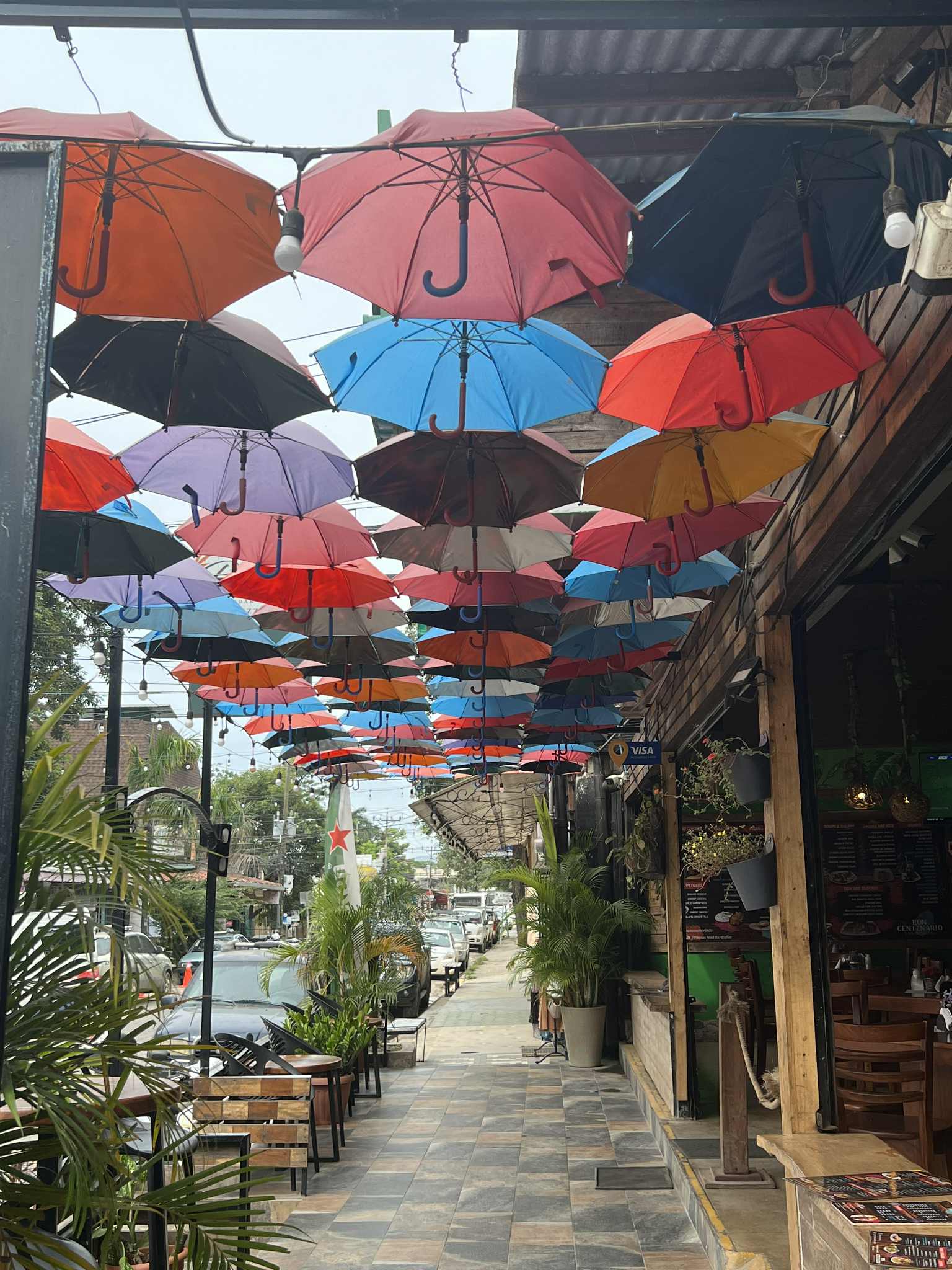 Picture of a bunch of colorful umbrellas hanging over a street in Tamarindo, Costa Rica.