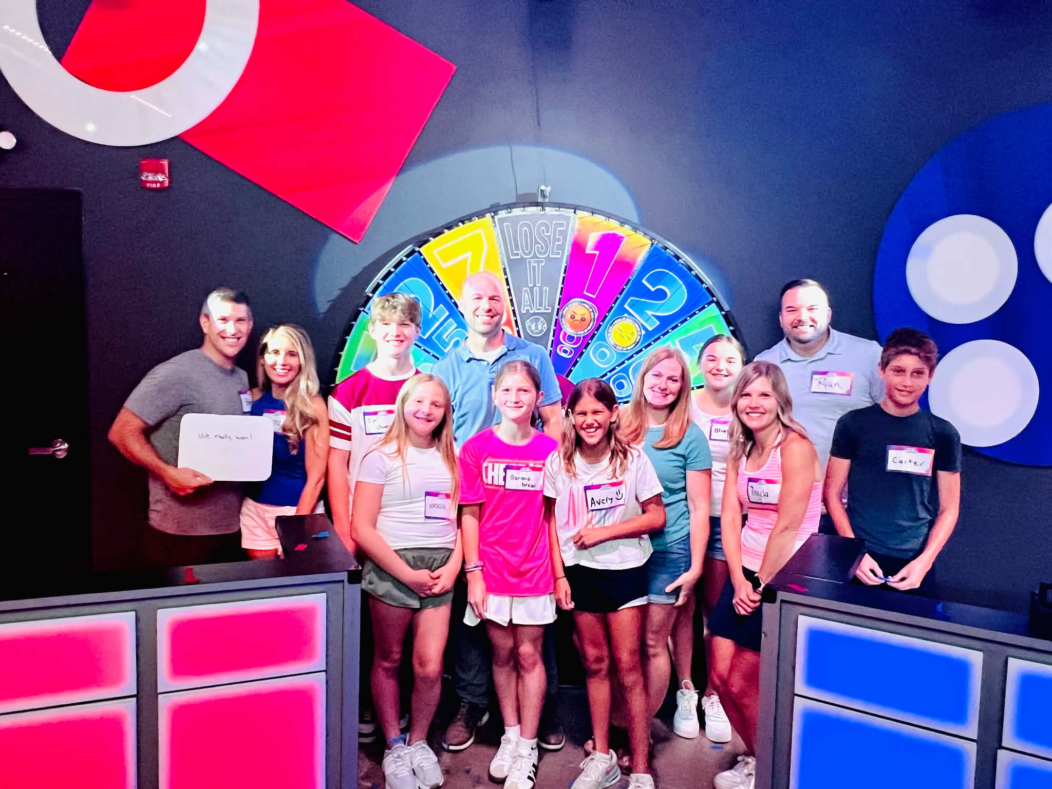 A group of adults and kids / teenagers as The Great Big Game Show in Nashville. They are all standing in front of a spinning wheel.
