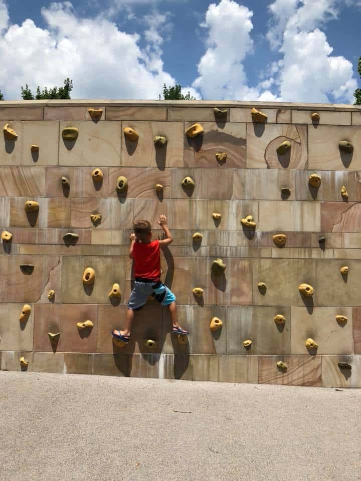 A little boy rock climbing at the park in downtown Nashville.
