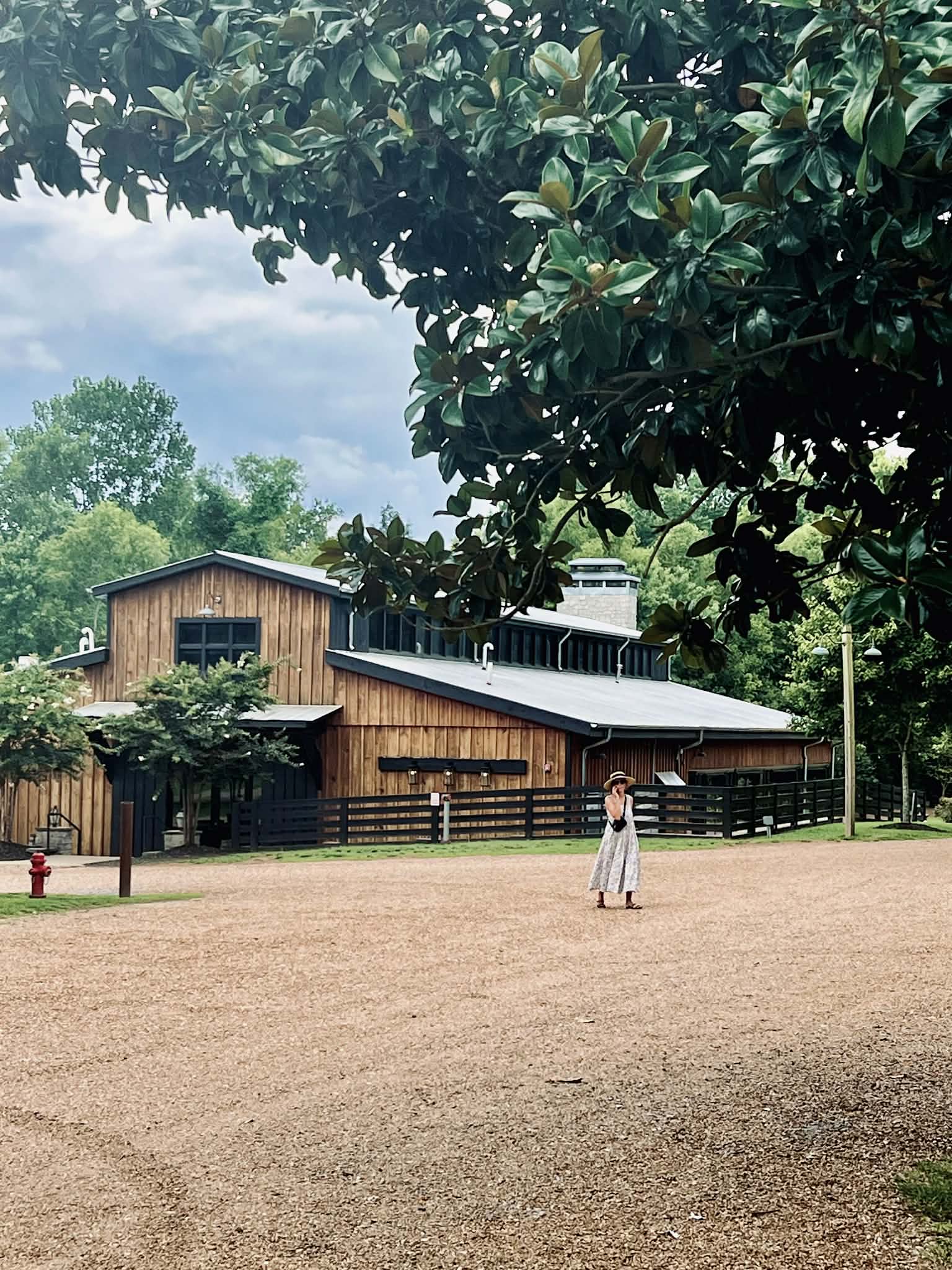 A woman walking in front of the beautiful barn at the coffee shop.