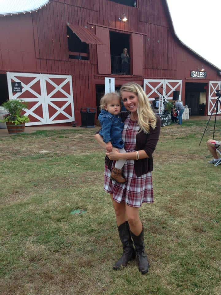A mom holding her daughter in front of the barn at Arrington Vineyards.