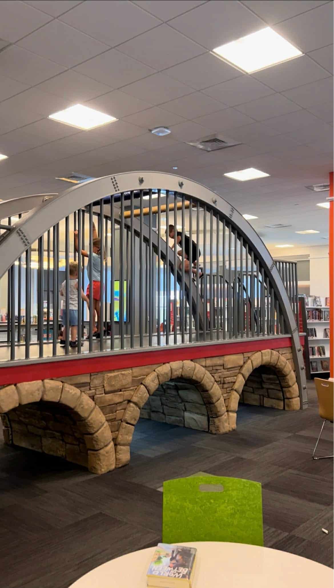 Two kids climbing on a small scale version of the Nashville city skyline.