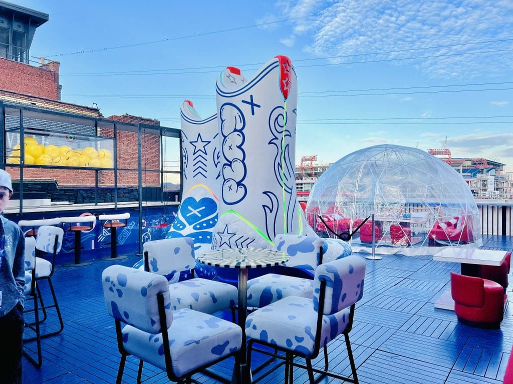 The rooftop of Play Playground showcasing two massive white cowboy boots and an igloo.