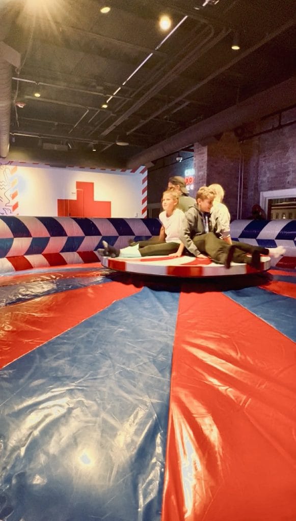 A family with kids on a spinning wheel for a game to see who can hold on the longest at Play Playground in Nashville.