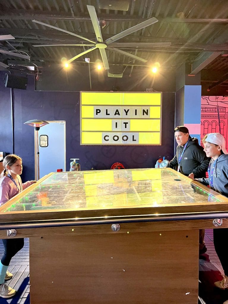 Kids with their dad playing a game in downtown Nashville at Play Playground. The game is a big box maze.