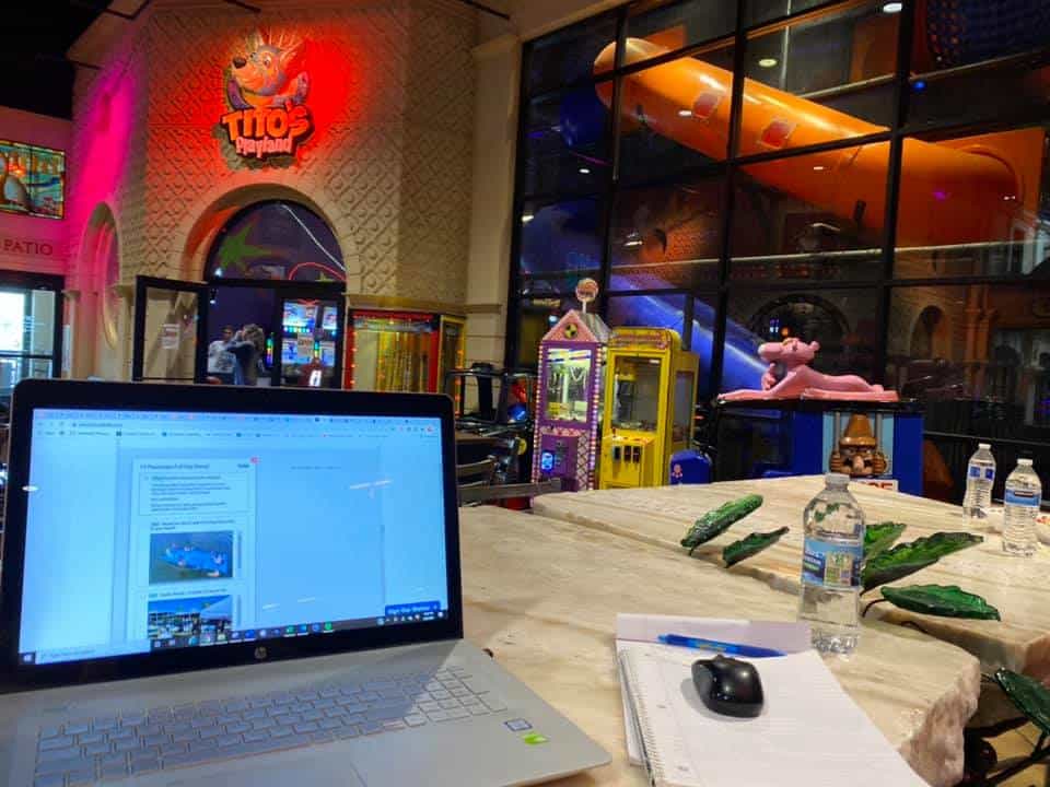 A mom working at her computer while being able to watch her kids play in the indoor playground at Plaza Mariachi in Nashville.