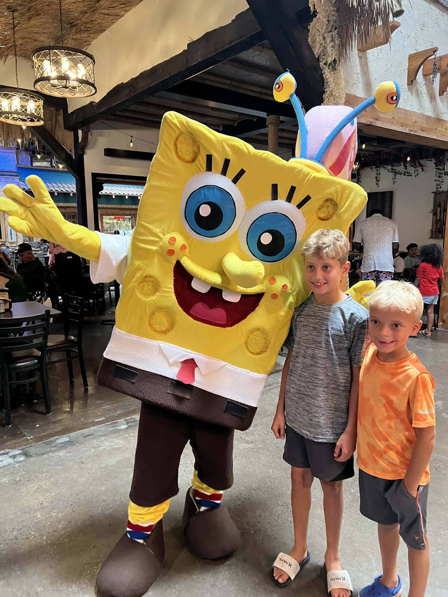 Two boys standing with a SpongeBob character at Plaza Mariachi for KidsFest in Nashville.