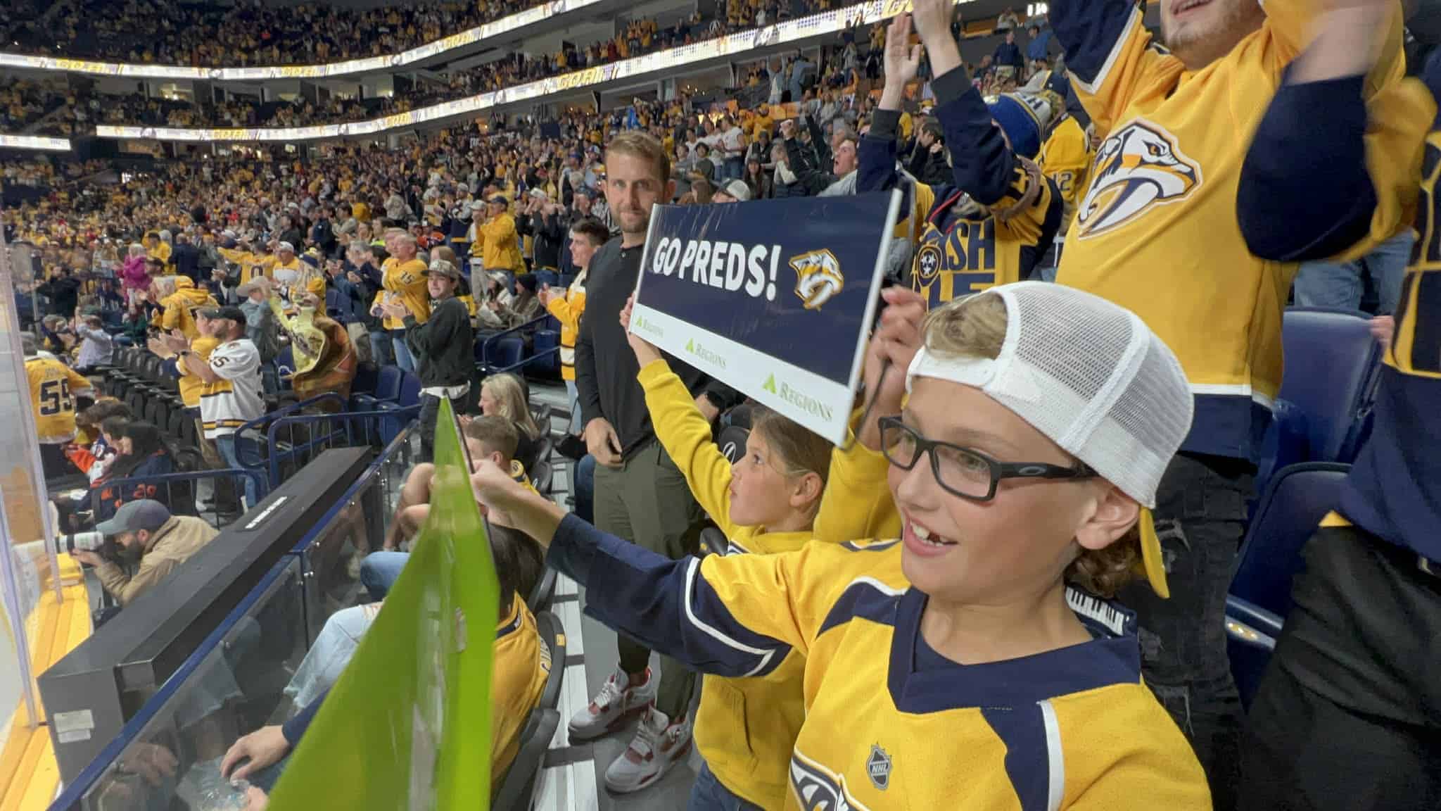 Two kids celebrate a goal at the Nashville Predators hockey game.