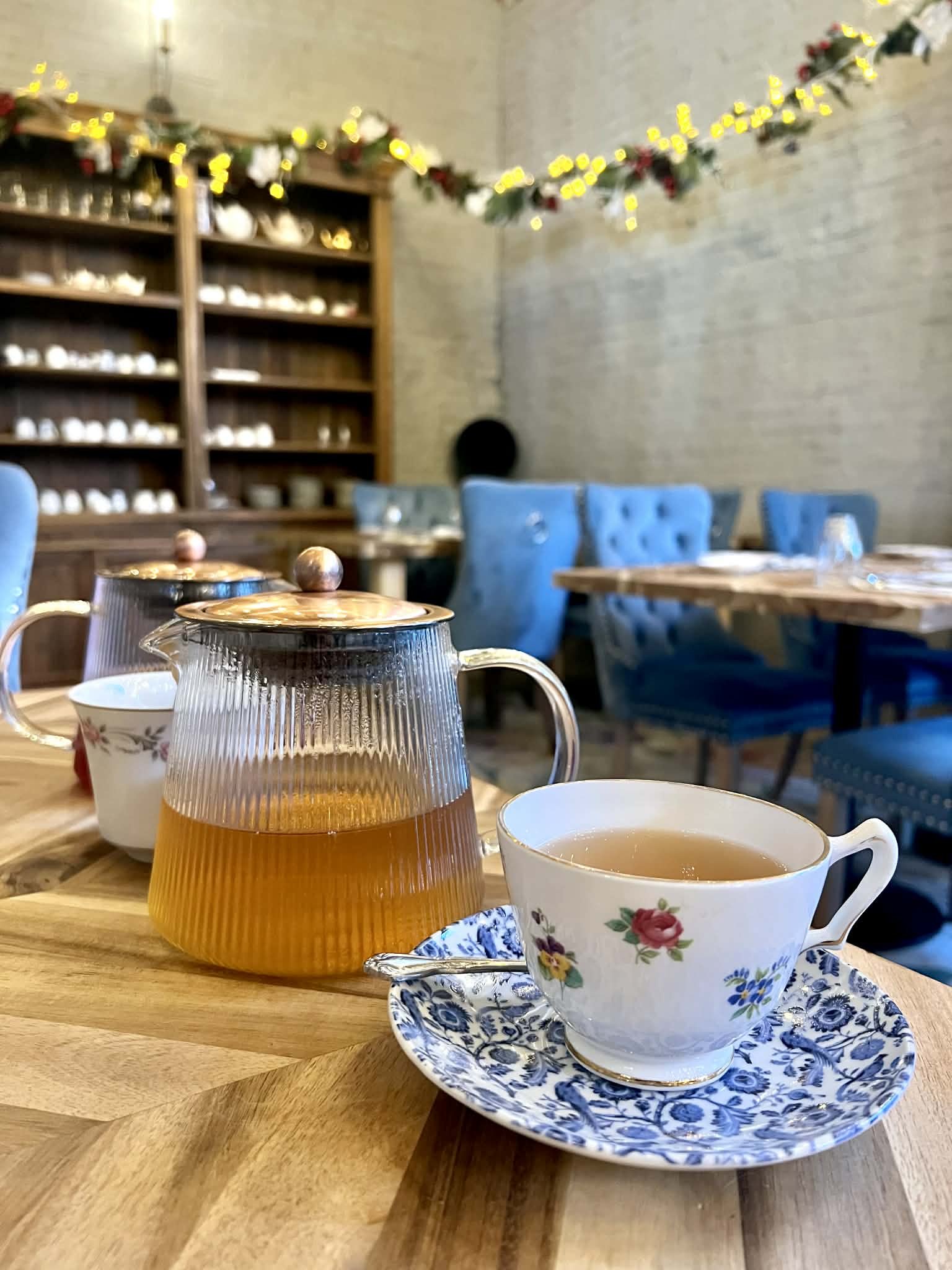 A beautiful tea cup with a pot of tea next to it.