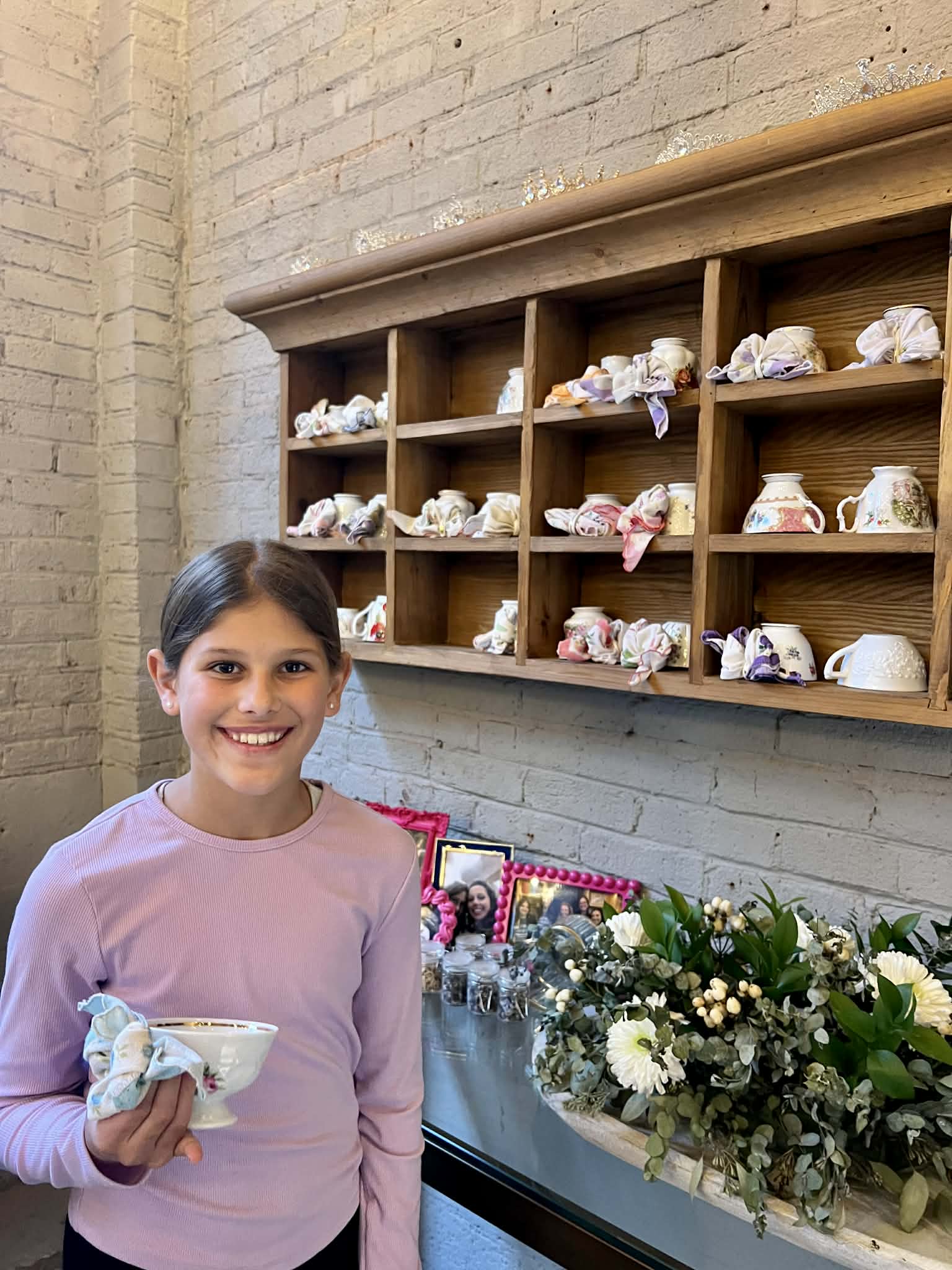 A little girl picking out her tea cup.