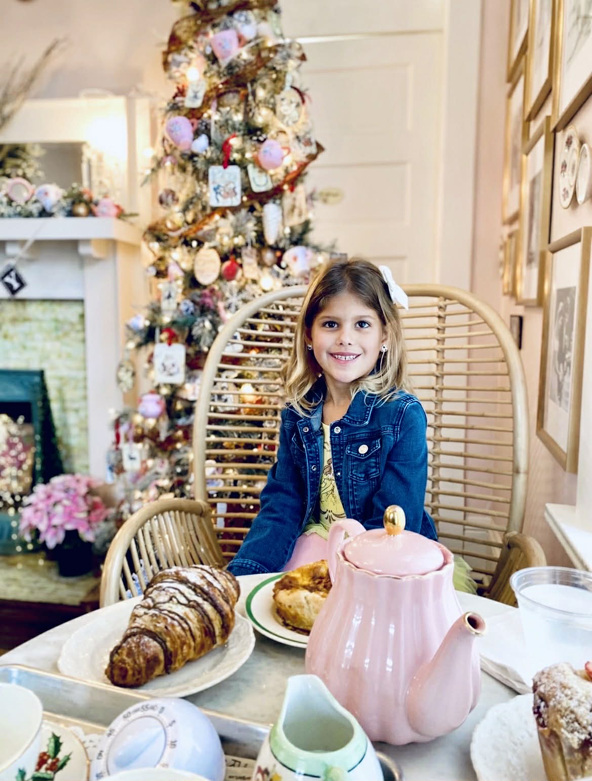 A little girl all dressed up having tea.