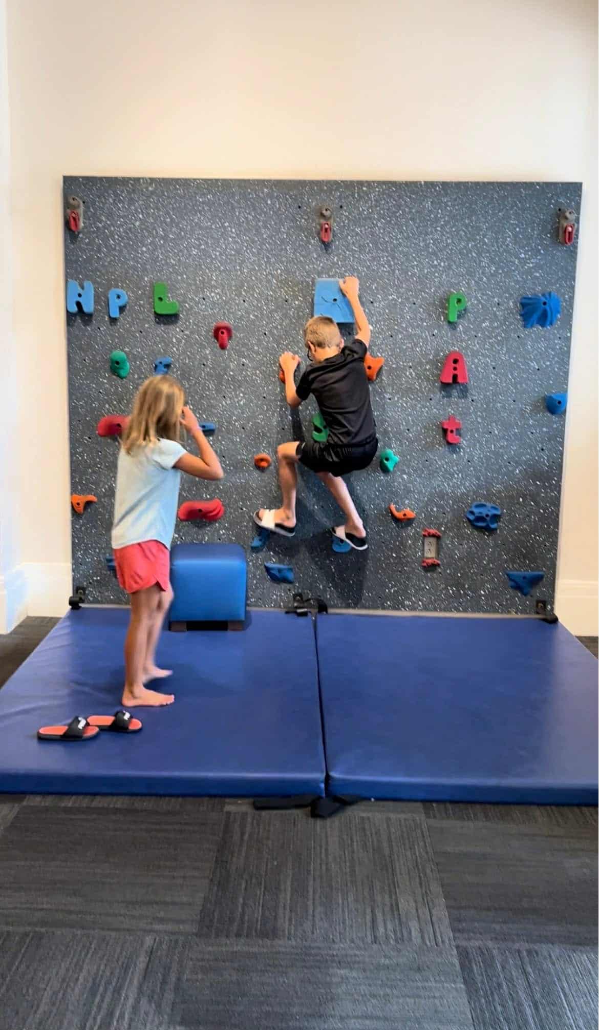 Two kids rock climbing at the Nashville Library.