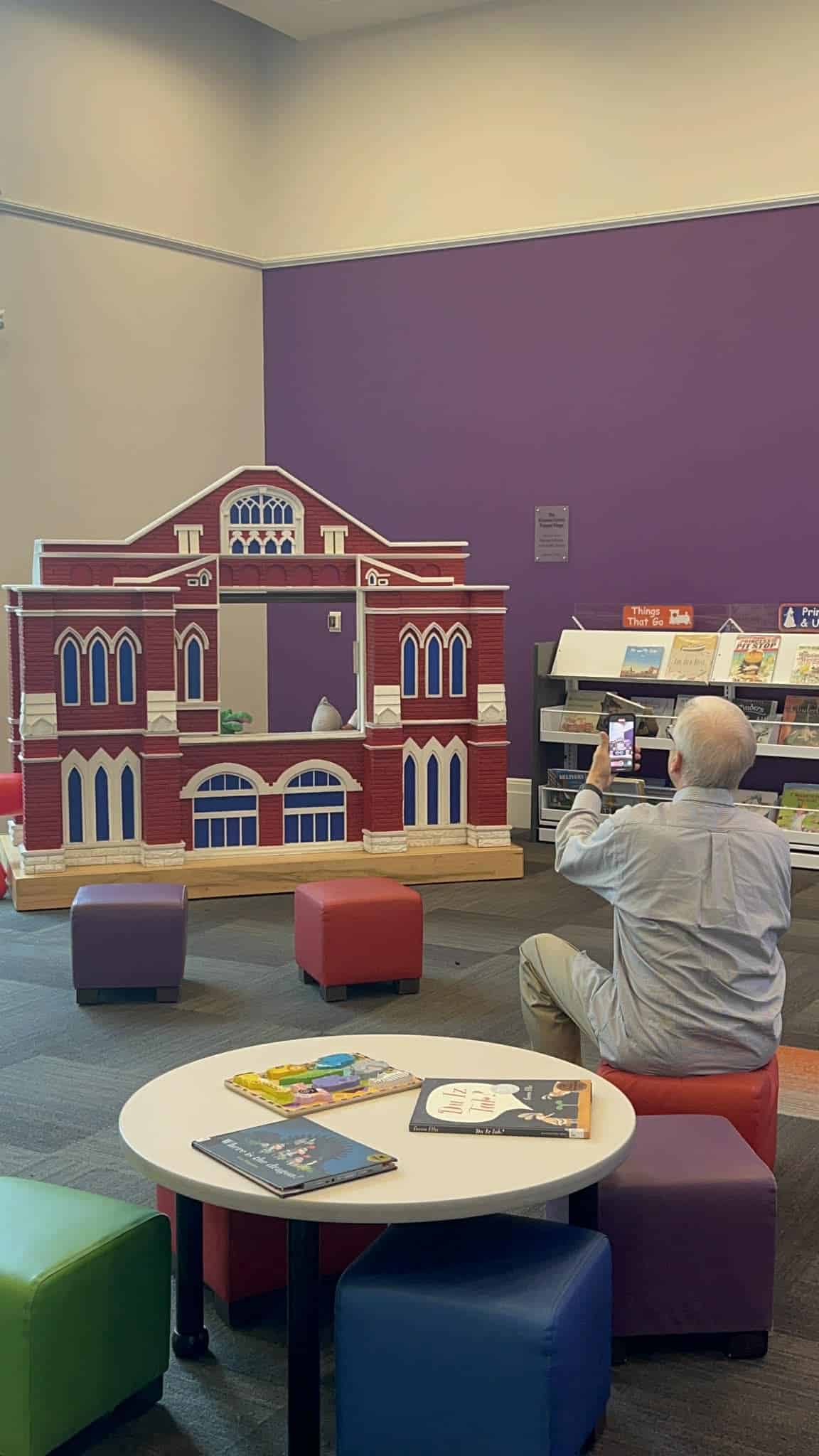 A grandpa watches his grandkids give a puppet show at the Nashville Library.