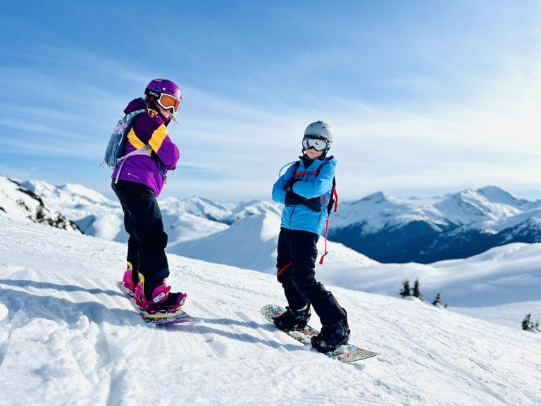 Two kids posing on the side of Whistler Blackcomb mountains.