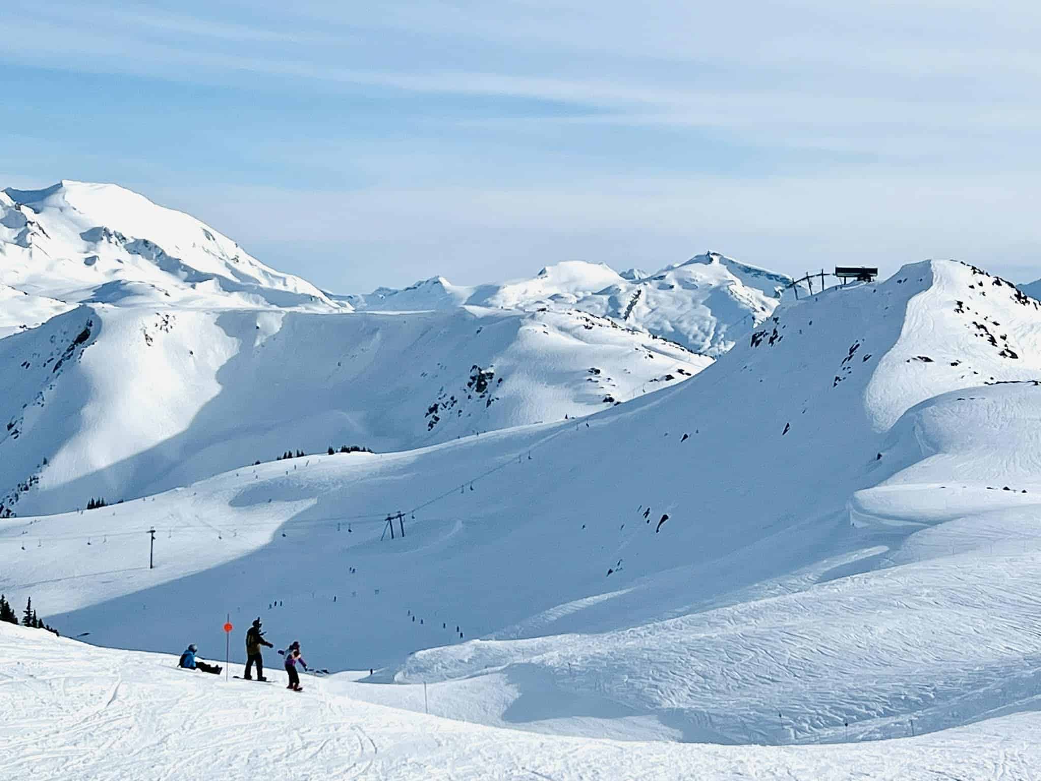 A dad and his two kids at Whistler snowboarding.
