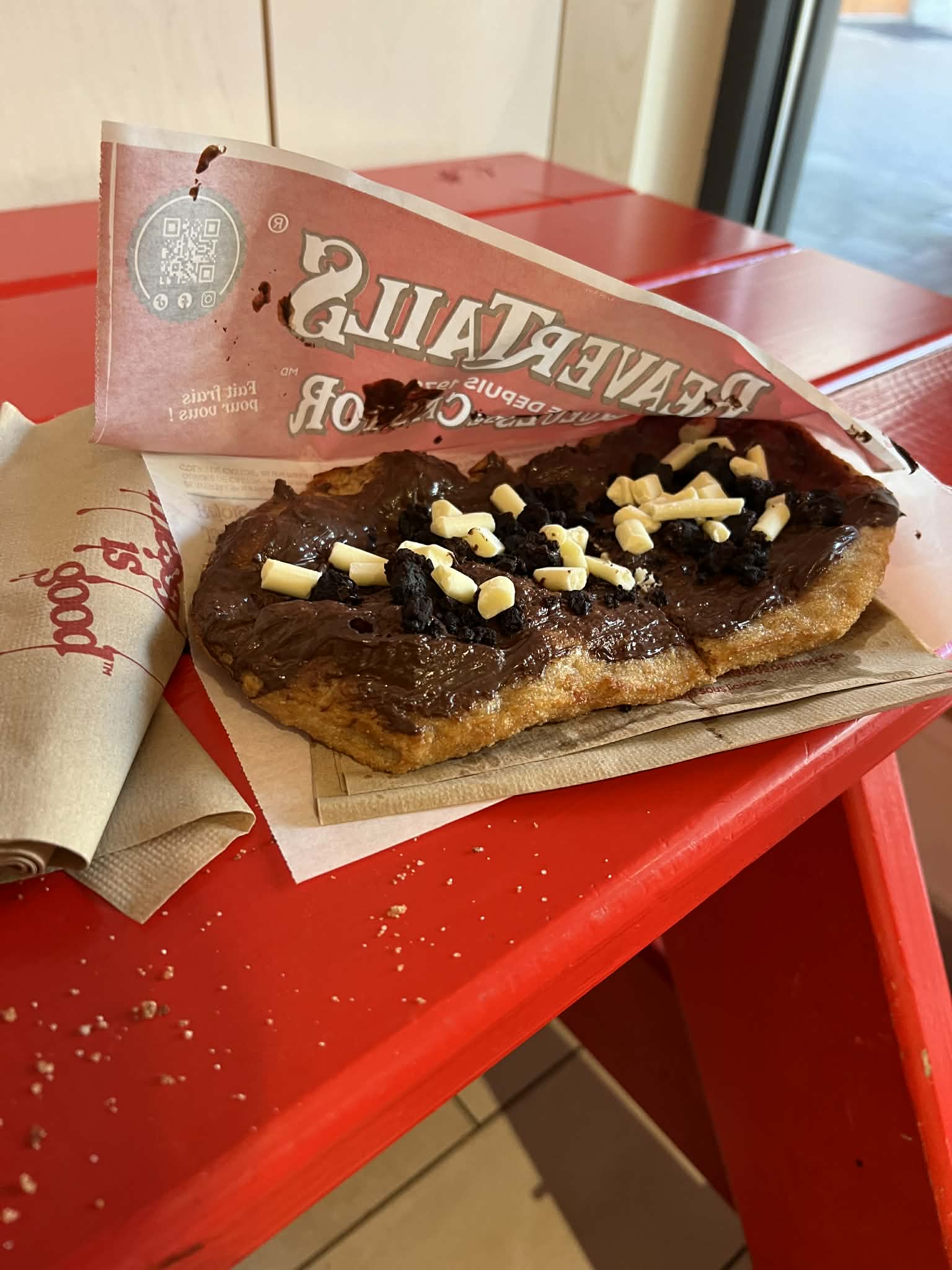 A "smores" flavored fried dough dessert on a red table.