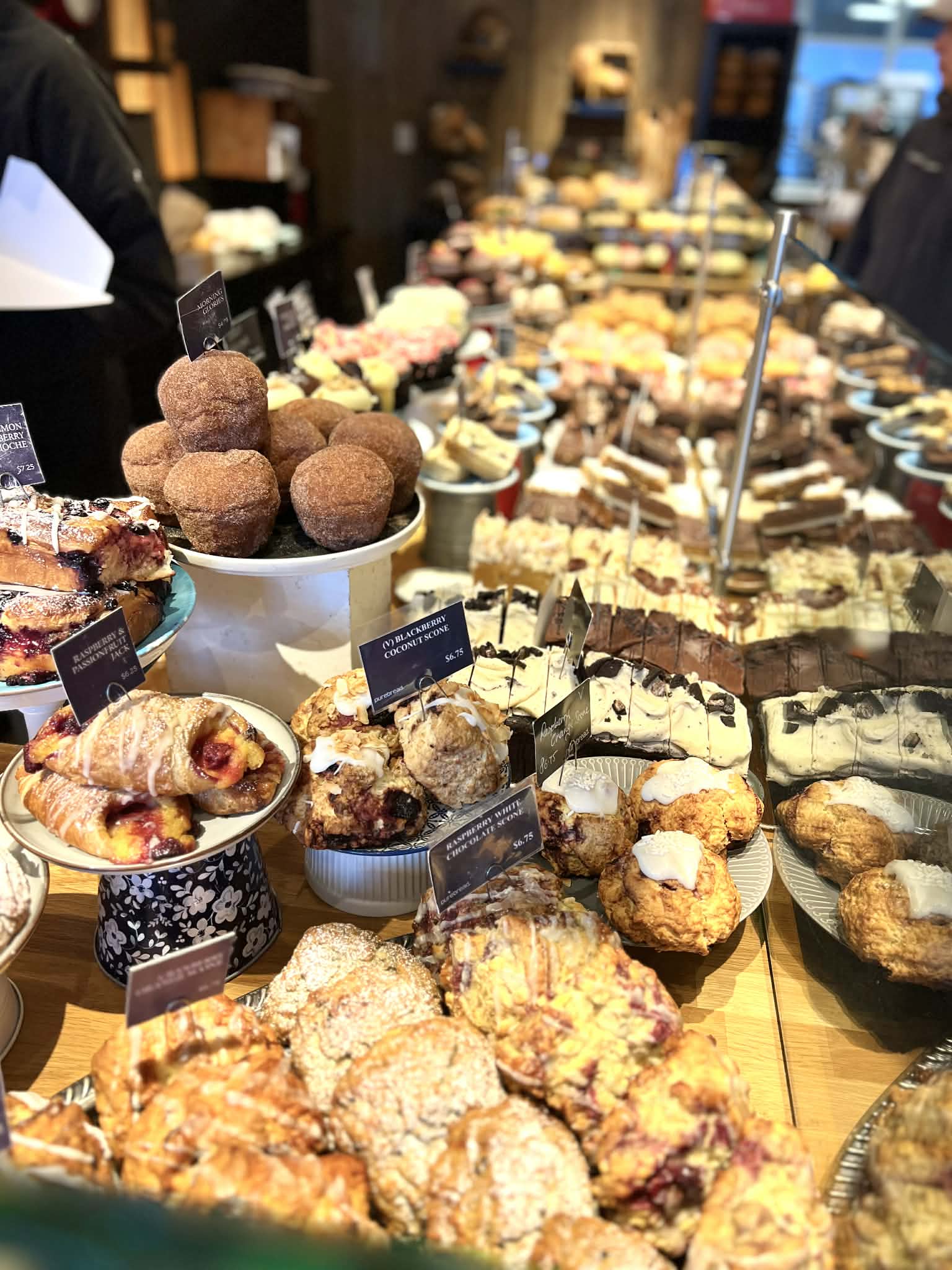 A ton of pastries ranging from donuts to croissants to cakes.