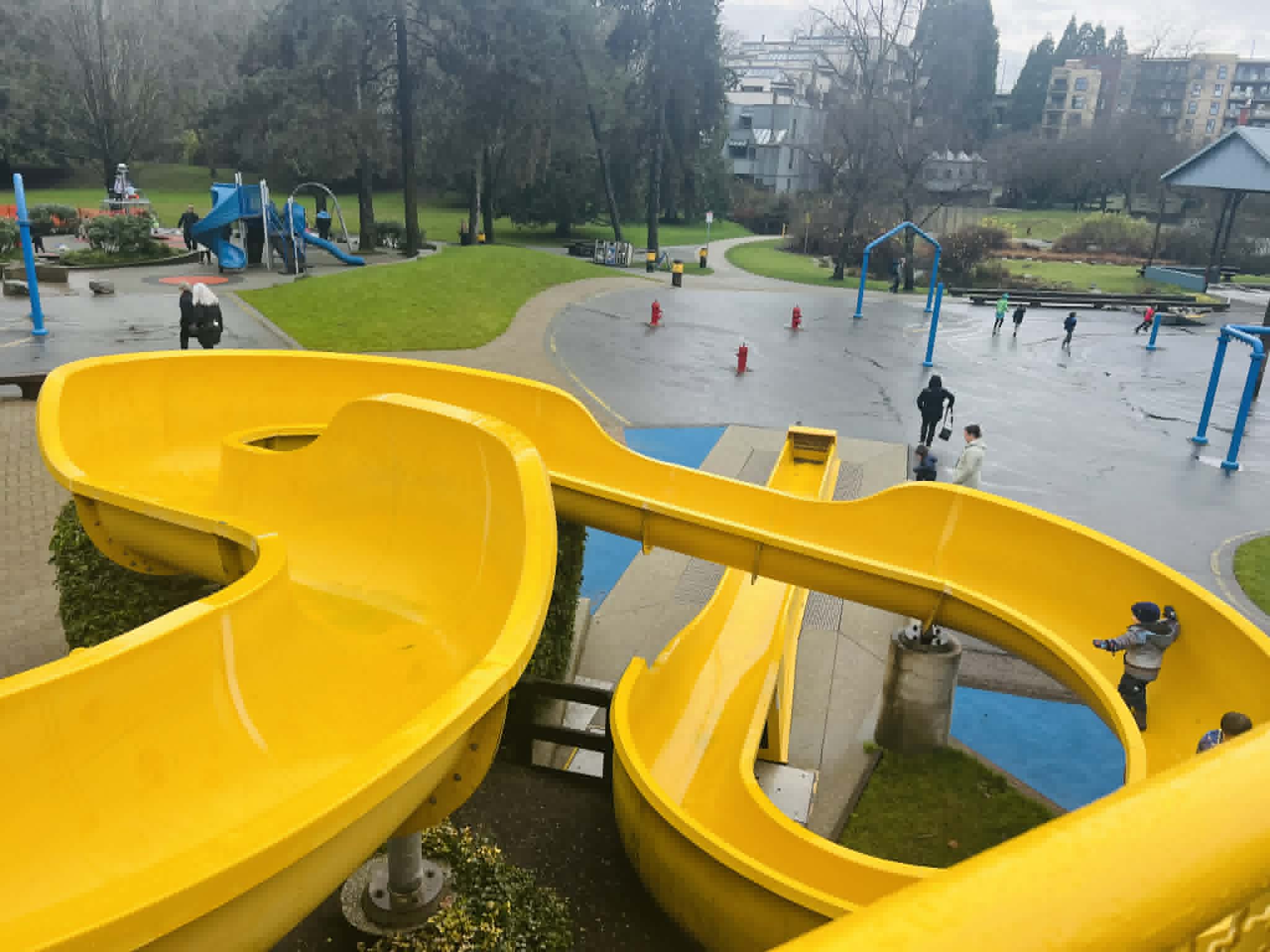 Kids playing on a winding, yellow slide at the Granville market in Vancouver.