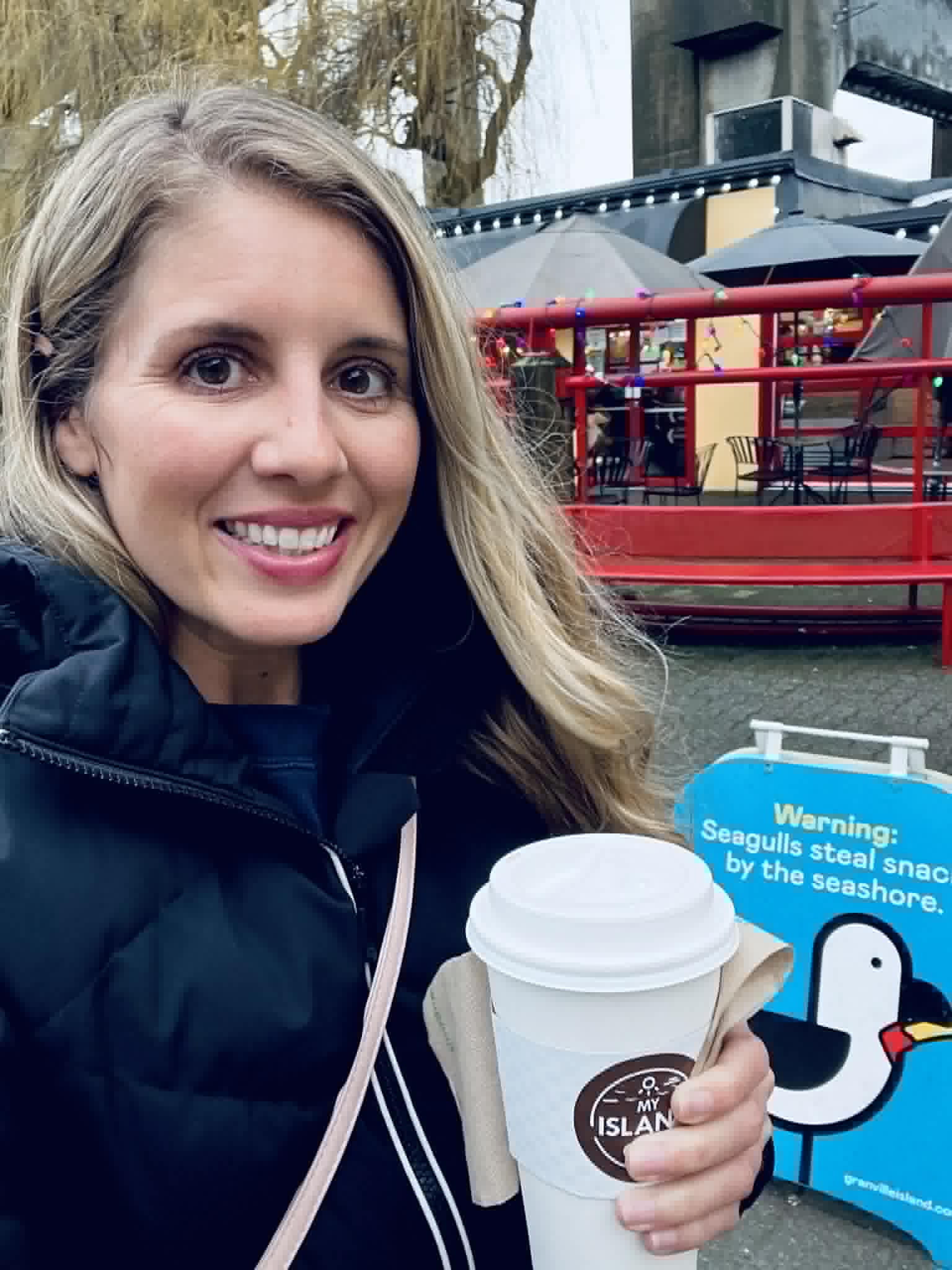 A woman holding her coffee in Vancouver.